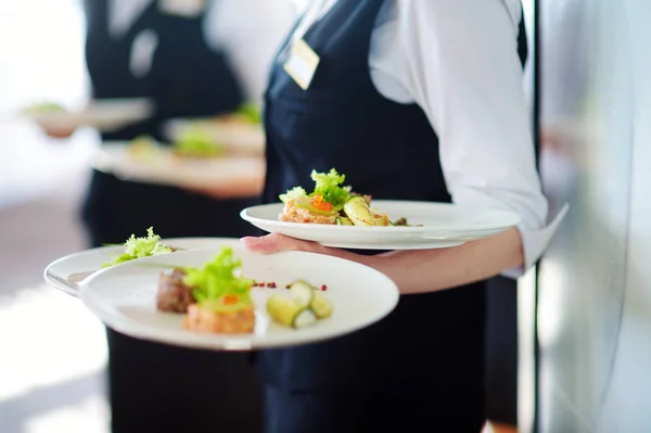 Официанты несут тарелки с посудой — стоковое фото