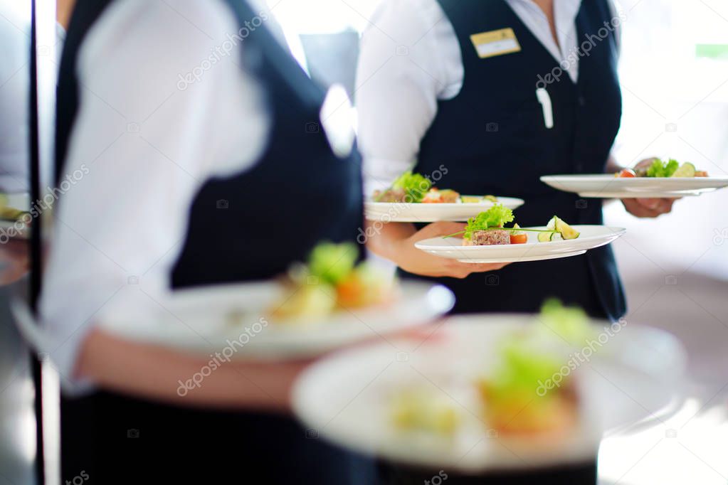 Waiters carrying plates with dishes  