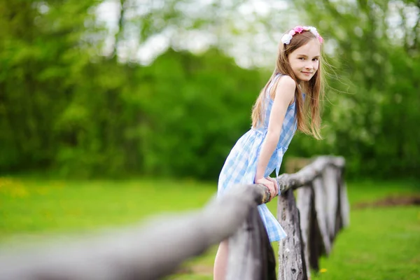 Dívka sedící na dřevěný plot — Stock fotografie