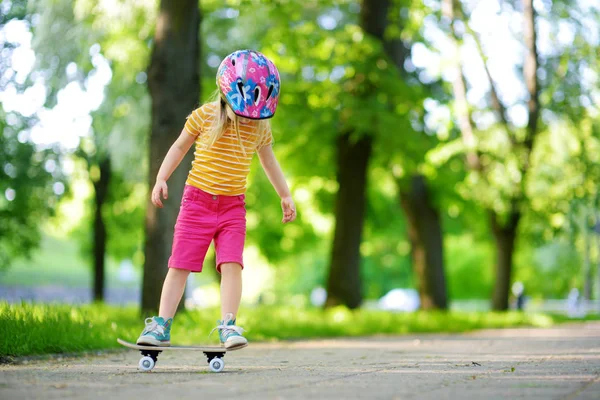 Девочка учится кататься на скейте — стоковое фото