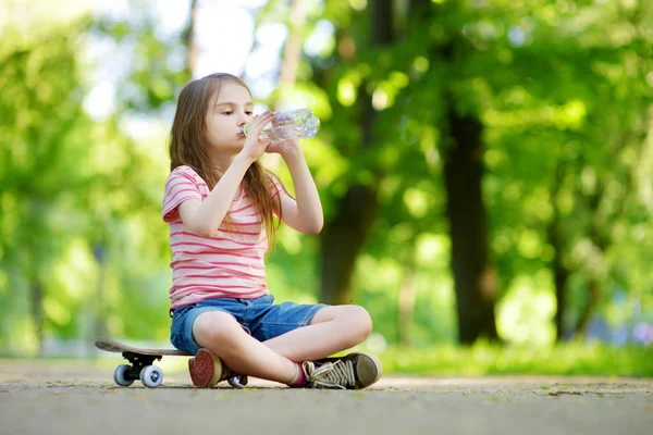 Gadis minum air di skateboard — Stok Foto