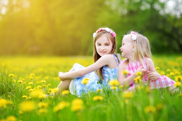 Girls in blooming dandelion meadow — Stock Photo, Image