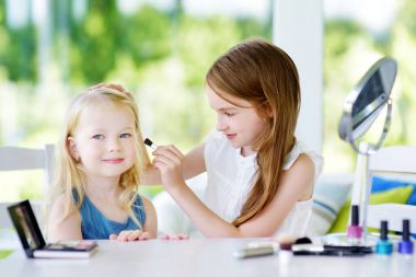 İki sevimli komik kız makyaj uygulamak 