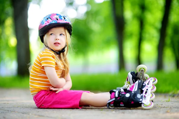 Mooi klein meisje leren rolschaatsen — Stockfoto