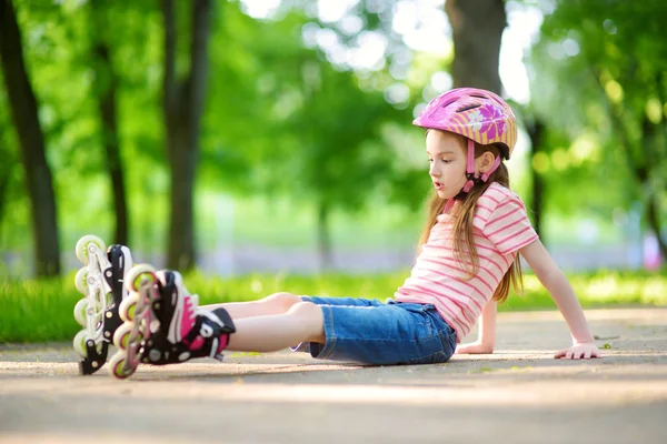Hübsches kleines Mädchen lernt Rollschuh fahren — Stockfoto