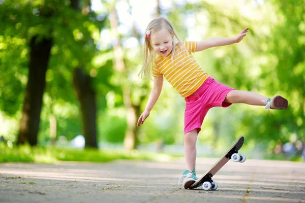Menina bonita aprendendo a skate — Fotografia de Stock