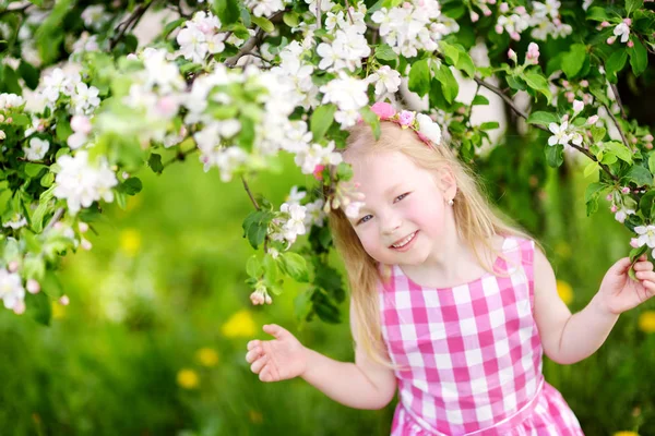 Schattig meisje in bloeiende appelboom — Stockfoto