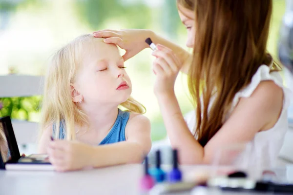 Two cute funny sisters applying make-up — Stock Photo, Image
