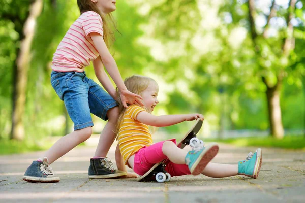 Dua gadis kecil yang cantik belajar skateboard — Stok Foto