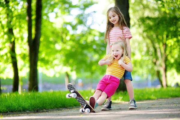 Două fetițe drăguțe care învață să skateboard — Fotografie, imagine de stoc