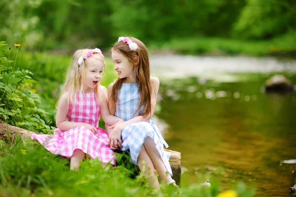 Deux adorables petites sœurs jouant au bord d'une rivière — Photo