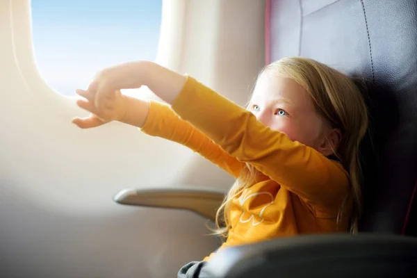 Adorável menina viajando de avião . — Fotografia de Stock