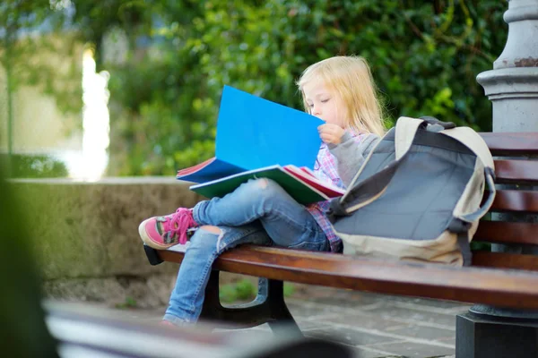 Adorável pequena estudante estudando ao ar livre — Fotografia de Stock