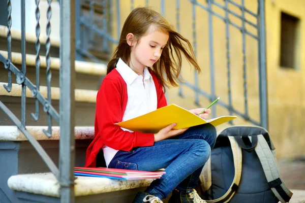 Adorable little schoolgirl studying outdoors — Stock Photo, Image