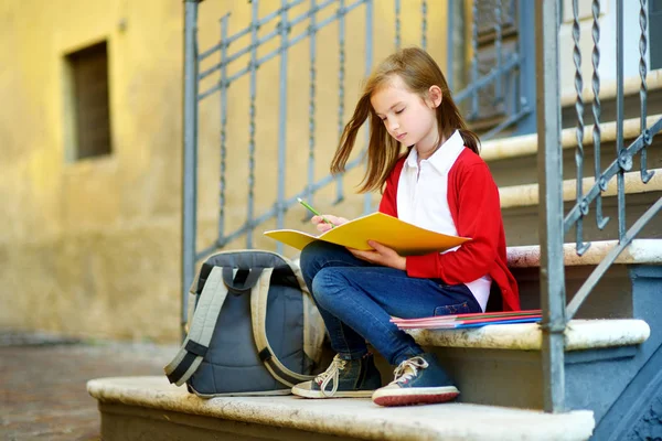 Schattige kleine schoolmeisje studeren buiten — Stockfoto