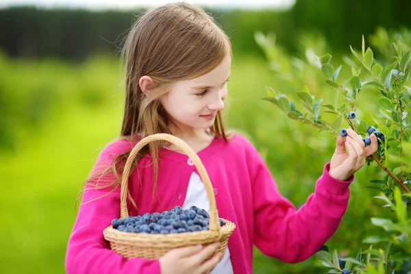 Söt liten flicka plocka färska bär — Stockfoto