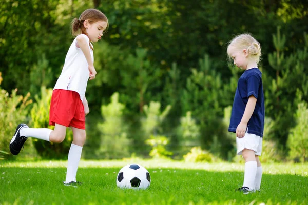 Дві милі маленькі сестри грають у футбол — стокове фото
