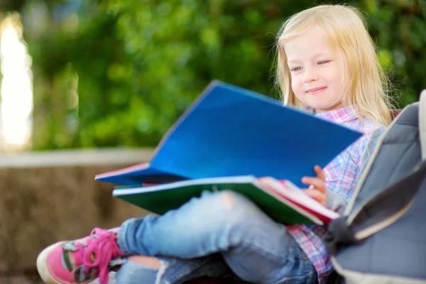 Schattige kleine schoolmeisje studeren buiten — Stockfoto