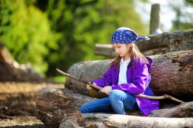 little girl sitting on tree logs clipart