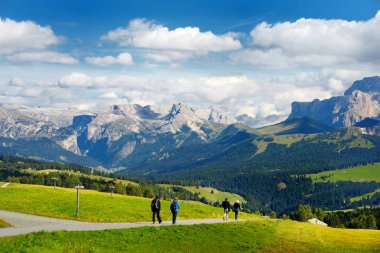  Tourists hiking on altitude Alpine meadow clipart