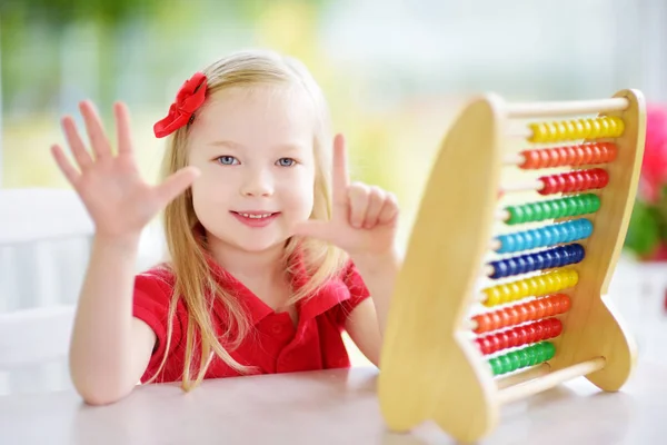 Niedliches kleines Mädchen spielt mit Abakus — Stockfoto