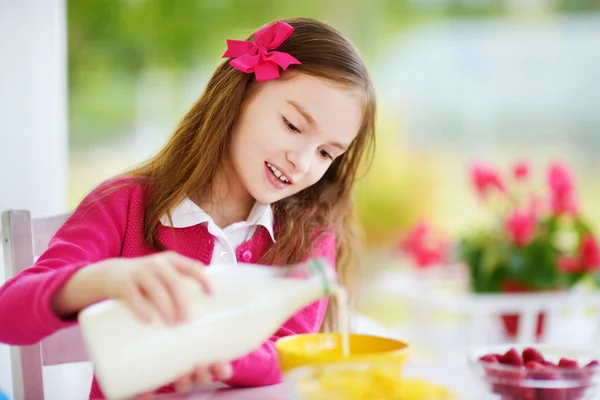 Pretty child purring milk in bowl — Stock Photo, Image