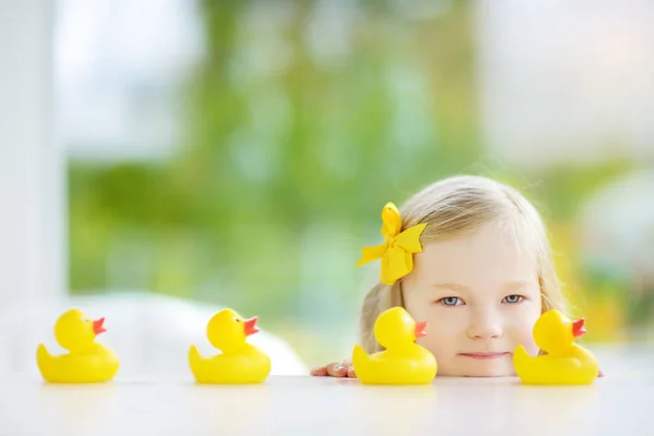 Little girl playing with rubber ducklings — Stock Photo, Image