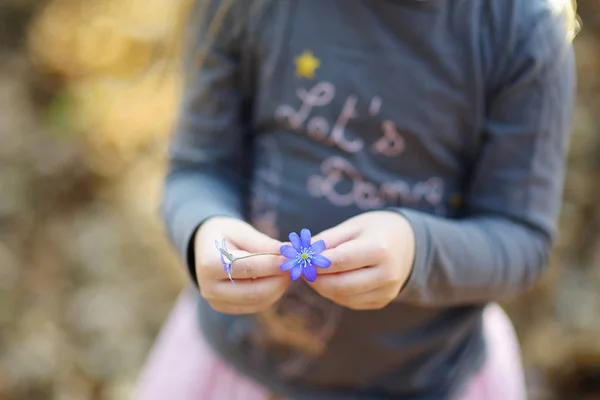 Kleines Mädchen mit blauen Blumen — Stockfoto