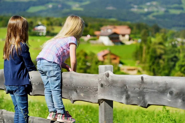 Ahşap çit oturan küçük kızlar — Stok fotoğraf