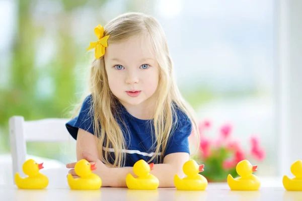 Маленькая девочка играет с резиновыми утятами — стоковое фото