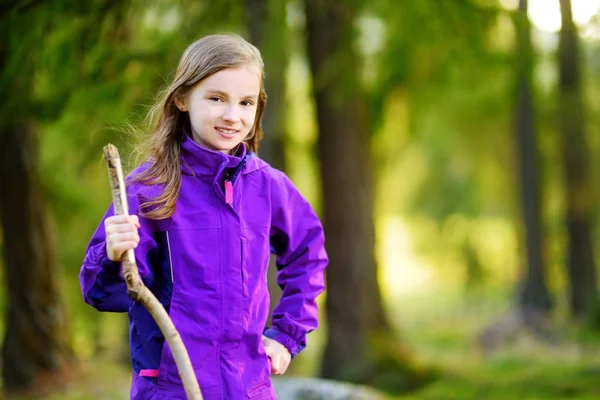 Fille debout avec bâton en bois dans la forêt — Photo