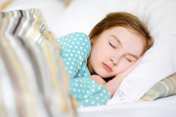 Adorable little girl sleeping in bed