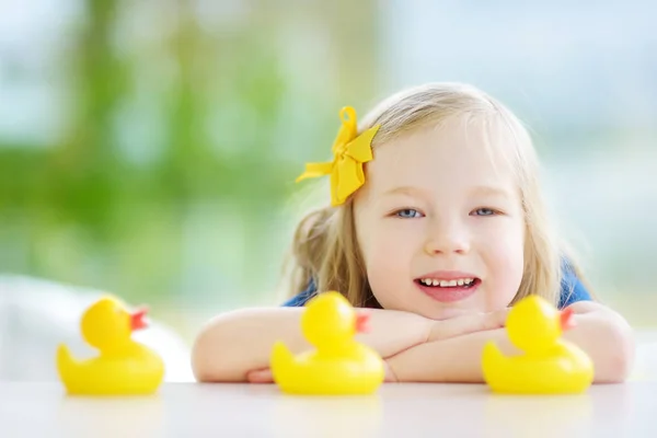 Little girl playing with rubber ducklings — Stock Photo, Image