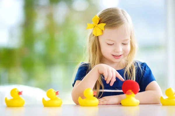 Lastik ördek yavrusu ile oynarken küçük kız — Stok fotoğraf