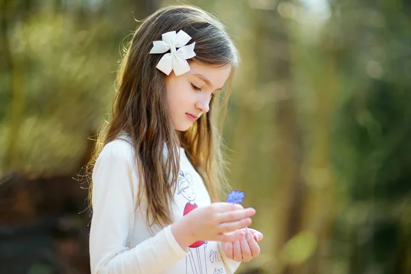 Menina segurando flor azul — Fotografia de Stock