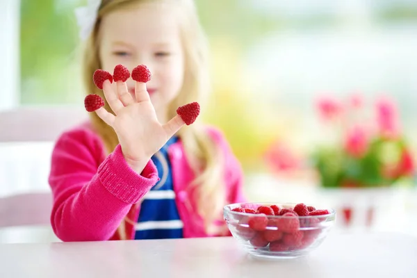 Child enjoying with raspberries — Stock Photo, Image