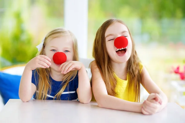 Little sisters wearing clown noses — Stock Photo, Image