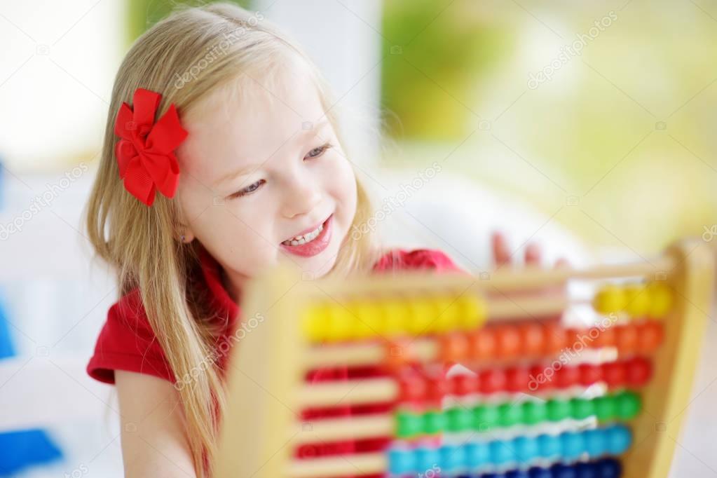 Cute little girl playing with abacus 