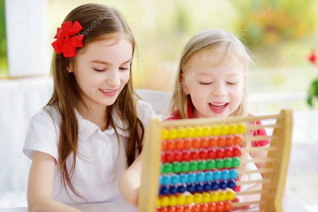 cute little girls playing with abacus
