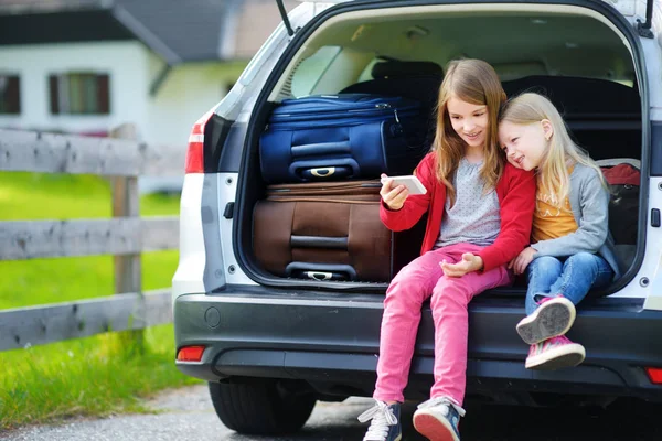 座っている女の子が車のトランクを開く — ストック写真