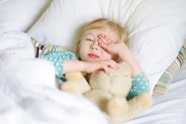 Liten flicka vaknar upp i sängen — Stockfoto