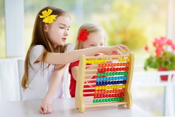 Cute little girls playing with abacus — Stock Photo, Image