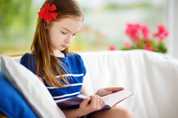 Meisje leesboek in wit woonkamer — Stockfoto