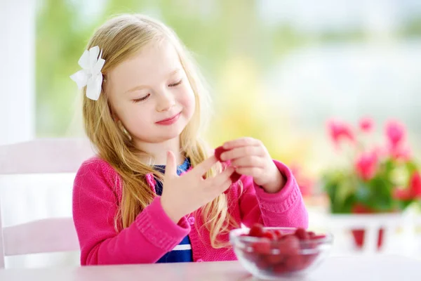 Linda niña comiendo frambuesas —  Fotos de Stock