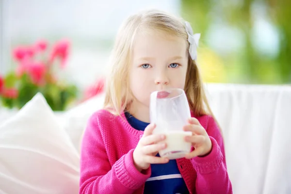 Linda niña bebiendo leche orgánica fresca — Foto de Stock