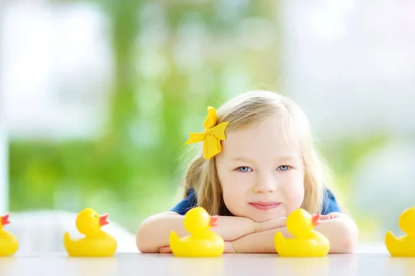 Little girl playing with rubber ducklings — Stock Photo, Image