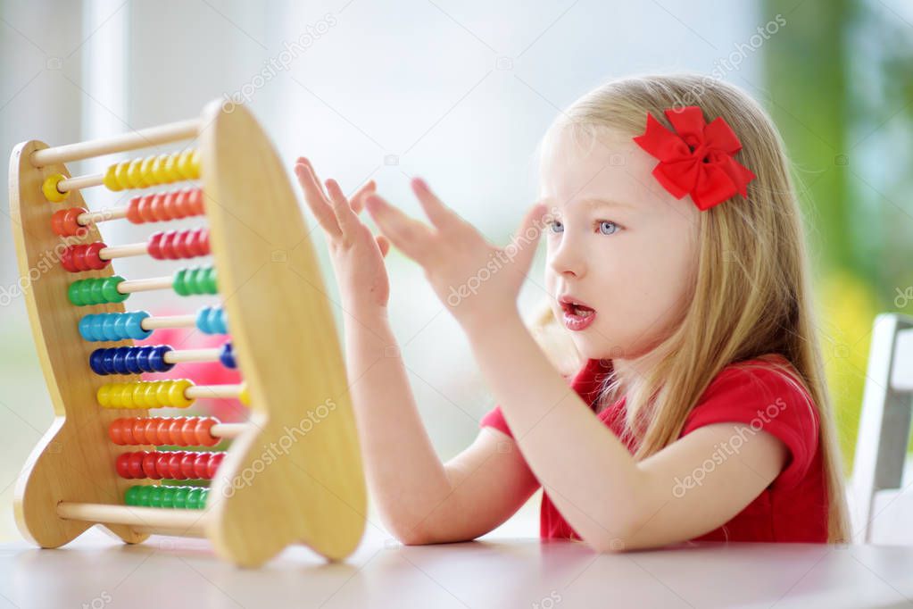 Cute little girl playing with abacus 