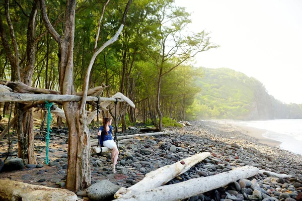 Female tourist relaxing on handmade swing — Stock Photo, Image