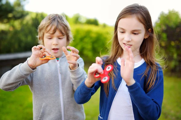 Två vänner som spelar med fidget spinnare — Stockfoto