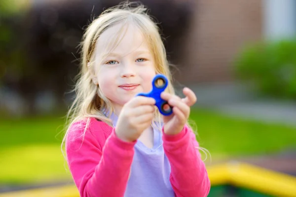 Meisje speelt met fidget spinner — Stockfoto
